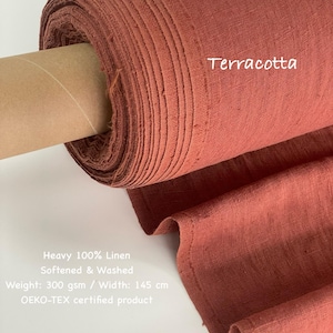 May include: A roll of terracotta-colored heavy 100% linen fabric. The fabric is softened and washed, with a weight of 300 gsm and a width of 145 cm. The text "Terracotta" is visible on the fabric.