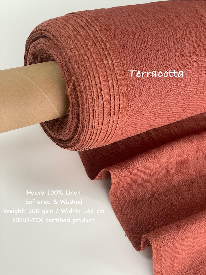 May include: A roll of terracotta-colored heavy 100% linen fabric. The fabric is softened and washed, with a weight of 300 gsm and a width of 145 cm. The text "Terracotta" is visible on the fabric.