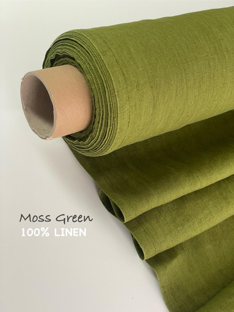 May include: A roll of moss green fabric with a visible woven texture. The fabric is wrapped around a cardboard core and partially unrolled. Text printed on the image reads: Moss Green 100% LINEN. The material has a matte finish and consistent color.
