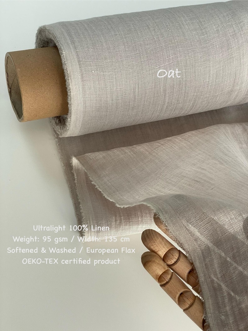 May include: A roll of light beige linen fabric labeled "Oat". The fabric is ultralight, 100% linen, and 135 cm wide. The image also includes text indicating the fabric is softened, washed, and OEKO-TEX certified.