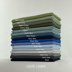 Może przedstawiać: Stos złożonych tkanin ze 100% lnu w r&oacute;żnych kolorach z etykietami Pear Green, Aqua Gray, Agave Green, Dusty Olive, Lagoon, Dusty Blue, Dark Denim, Navy Blue, Royal Blue, Blue Indigo, Baby Blue, Pearl Blue, Silver Gray, Steel Gray, Dark Gray oraz Black.