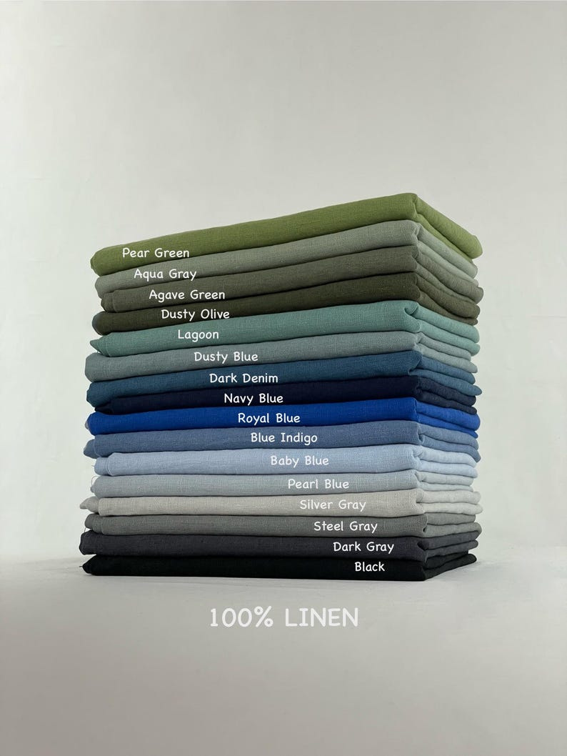 Może przedstawiać: Stos złożonych tkanin ze 100% lnu w r&oacute;żnych kolorach z etykietami Pear Green, Aqua Gray, Agave Green, Dusty Olive, Lagoon, Dusty Blue, Dark Denim, Navy Blue, Royal Blue, Blue Indigo, Baby Blue, Pearl Blue, Silver Gray, Steel Gray, Dark Gray oraz Black.