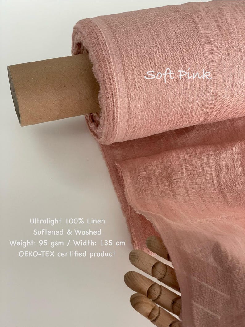 May include: A roll of soft pink ultralight 100% linen fabric. The fabric is softened and washed, with a weight of 95 gsm and a width of 135 cm. The text "Soft Pink" is visible on the fabric. The product is OEKO-TEX certified.