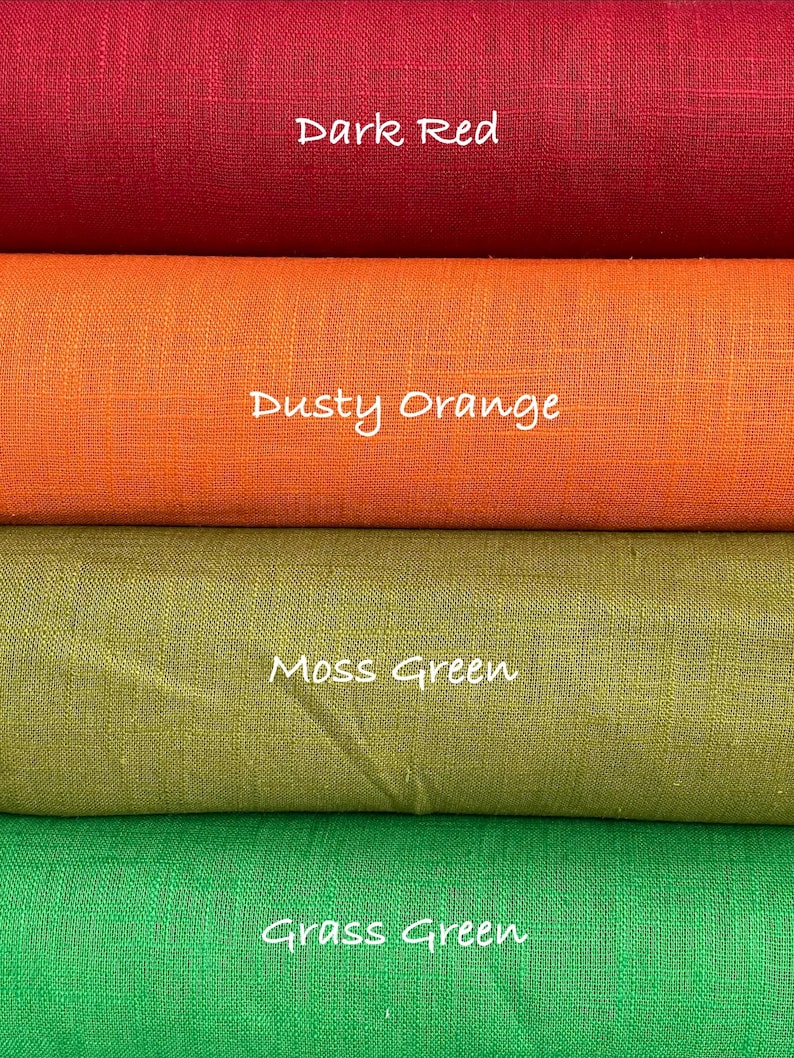 May include: Four stacked rolls of fabric featuring a visible woven texture. The top roll is labeled Dark Red, the second is Dusty Orange, the third is Moss Green, and the bottom roll is labeled Grass Green. Each color is clearly identified by text.