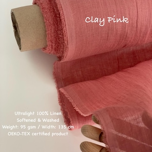 May include: A roll of clay pink 100% linen fabric. The fabric is ultralight, softened, and washed. The width is 135 cm. The text "Clay Pink" is written on the fabric. The fabric is OEKO-TEX certified.