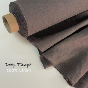 May include: A roll of deep taupe 100% linen fabric. The fabric is a muted, earthy tone, with a slightly textured appearance. The roll is partially unraveled, revealing the raw edge of the material. The text "Deep Taupe" and "100% LINEN" is visible.