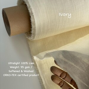 May include: A roll of ivory-colored, ultralight 100% linen fabric. The fabric is labeled as 95 gsm, softened, washed, and ORKO-TEX certified. The word "Ivory" is written on the fabric.
