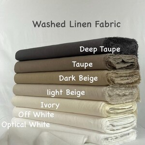 K&ouml;nnte beinhalten: Ein Stapel aus sieben Rollen gewaschenem Leinenstoff in verschiedenen neutralen Farbt&ouml;nen. Die von oben nach unten beschrifteten Farben sind Deep Taupe, Taupe, Dark Beige, light Beige, Ivory, Off White und Optical White. Der Stoff hat sichtbare Fransen.
