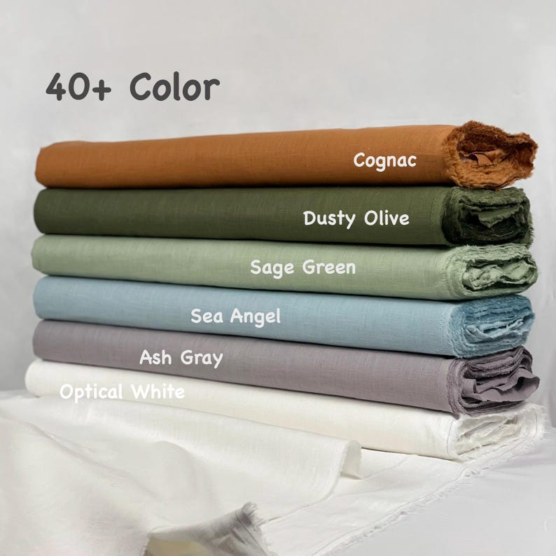 May include: A stack of six folded fabric bolts in various colors labeled 40+ Color, Cognac, Dusty Olive, Sage Green, Sea Angel, Ash Gray, and Optical White. Each bolt features a textured weave with frayed edges, arranged horizontally in a vertical pile.