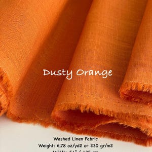 K&ouml;nnte beinhalten: Ein Ballen aus stauborangem, gewaschenem Leinenstoff mit sichtbarer Webstruktur. Der Text auf dem Bild lautet: Dusty Orange, Washed Linen Fabric, Weight: 230 gr/m2, Width: 135 cm. Der Stoff ist gefaltet und zeigt weiche, drapierte Lagen.