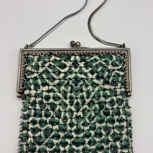 May include: Vintage green and white beaded purse with a silver-tone metal frame and chain strap. The purse features a geometric pattern of green and white beads, and a clasp closure. A classic accessory.