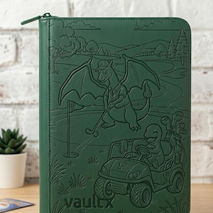 May include: A dark green zippered trading card binder featuring an embossed illustration of a dragon-like creature playing golf and a smaller creature driving a golf cart. The word vaultx is embossed in the bottom left corner of the cover.