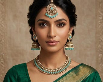 May include: A gold-toned jewelry set featuring a necklace, matching bell-shaped drop earrings, and a maang tikka headpiece. Each piece is adorned with small white pearls and round, light blue stones set in intricate metalwork patterns.