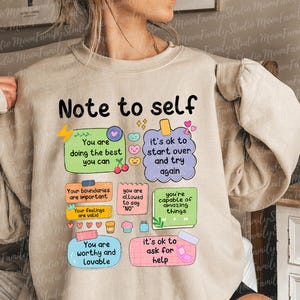 Może przedstawiać: Beżowa bluza z napisem "Note to self" i kolorowymi karteczkami z pozytywnymi afirmacjami. Notatki zawierają zwroty takie jak "Dajesz z siebie wszystko" i "Możesz zacząć od nowa i spr&oacute;bować ponownie."
