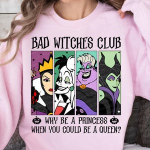 May include: Light pink sweatshirt with the text "BAD WITCHES CLUB" above a graphic of four cartoon villains. Below the graphic, the text reads "WHY BE A PRINCESS WHEN YOU COULD BE A QUEEN?"