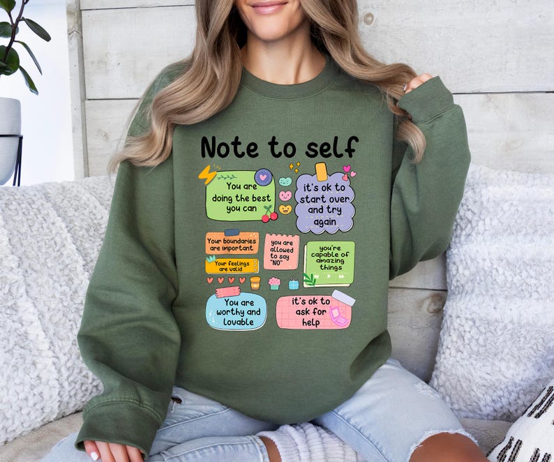 Może przedstawiać: Zielona bluza z napisem "Note to self" i inspirującymi wiadomościami na kolorowych karteczkach samoprzylepnych. Wiadomości obejmują "You are doing the best you can" i "You are worthy and lovable."