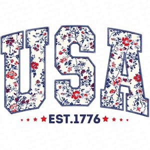 Può includere: La parola "USA" in un motivo floreale con fiori rossi e blu, delineata in materiale blu simile al denim, su sfondo bianco. Sotto la parola "USA" c'è il testo "EST.1776" con stelle rosse.