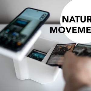 3D-printed white trading card scanner and dispenser tray with a built-in phone stand. Designed for TCG, MTG, Pokémon, and Lorcana, allowing easy card scanning with apps like Manabox, TCGPlayer, and Delver Lens. Perfect for collectors and sellers.