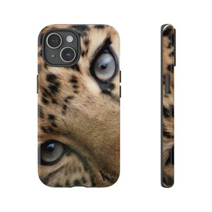 May include: Close-up of a leopard's face with a blue eye and brown and black spots. The image is on a black phone case.