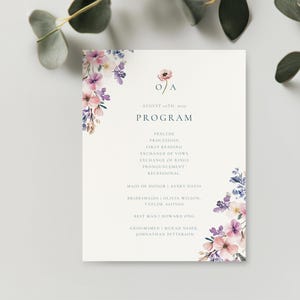 May include: A wedding program with a floral design in shades of pink, purple, and blue. The program includes the wedding date, the names of the wedding party, and the order of events. The text is in a blue font.
