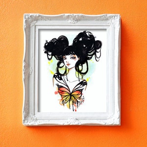 May include: A watercolor painting of a woman with black hair styled in two buns. She is wearing a butterfly-shaped top with orange, yellow, and red accents. The background is a soft yellow with watercolor splatters.
