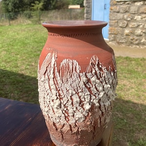 Peut inclure: Un vase en céramique brun rougeâtre fait à la main avec un motif blanc craquelé texturé. Le vase a une base large, un corps cylindrique et un bord légèrement évasé. L'extérieur présente un motif organique unique.
