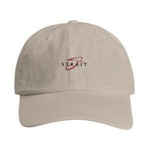 May include: A beige baseball cap with a red and black embroidered logo that says "STRAIT".