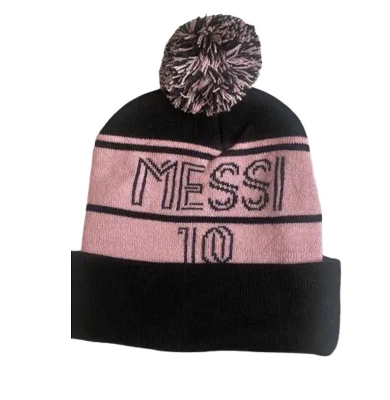 May include: Black and pink knit beanie with a pom pom on top. The beanie has the word "MESSI" and the number "10" embroidered on the front.
