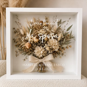 Op de afbeelding: Een witte schaduwdooslijst met een boeket gedroogde bloemen in beige, crème en groene tinten, vastgebonden met een lichtbeige lint. De tekst "il mio bouquet da sposa" staat erboven, "ISABELLE & FRANCESSCO 21.03.2026" staat eronder.