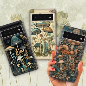 Peut inclure: Trois coques de t&eacute;l&eacute;phone avec un motif de champignons et de fleurs. Les coques sont noires, blanches et bleu fonc&eacute; avec une vari&eacute;t&eacute; de champignons et de fleurs.