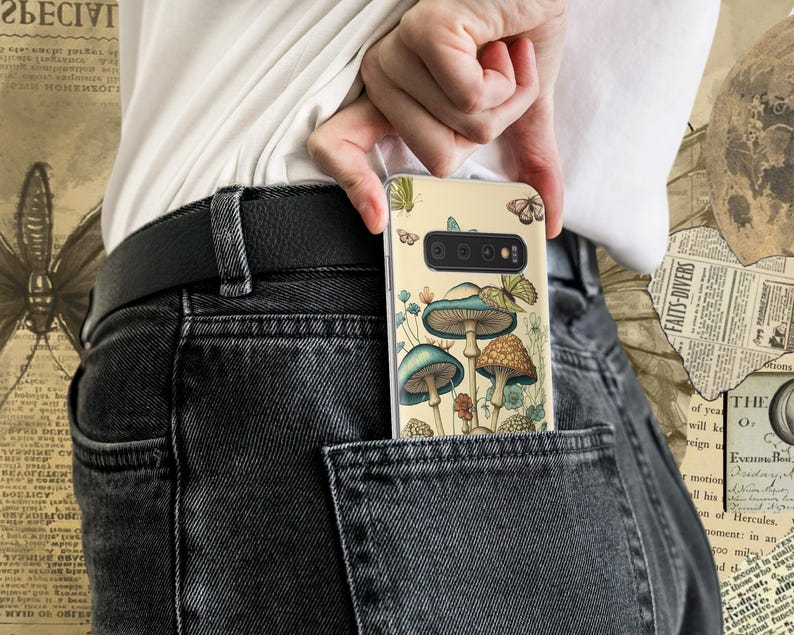 Peut inclure: Une coque de t&eacute;l&eacute;phone avec un fond beige et une illustration color&eacute;e de champignons et de papillons. La coque est dans une poche arri&egrave;re d'un jean fonc&eacute;.