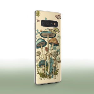 Peut inclure: Une coque de t&eacute;l&eacute;phone avec un fond cr&egrave;me et une illustration color&eacute;e de champignons aux chapeaux bleus et verts. L'illustration comprend des papillons et des fleurs.