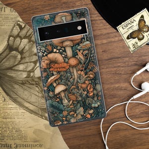 Peut inclure: Une coque de t&eacute;l&eacute;phone avec un fond bleu fonc&eacute; et une illustration color&eacute;e de champignons et de fleurs. La coque a une d&eacute;coupe pour l'appareil photo du t&eacute;l&eacute;phone.