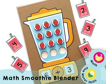 May include: A cardboard game for kids featuring a yellow blender with red strawberry lids. The game includes a number of red cups with numbers on them. The text on the game board reads "Math Smoothie Blender".