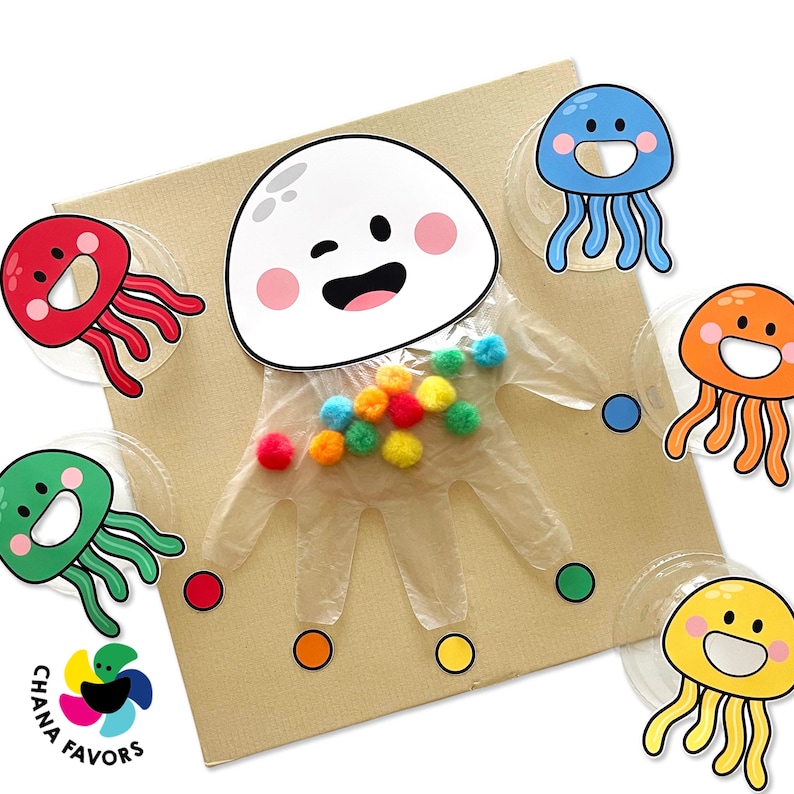 May include: A white plastic glove with a smiling face and rainbow pom-poms. The glove is surrounded by colourful jellyfish cutouts and small coloured circles.