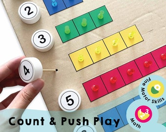 May include: A colorful counting and pushing activity for kids.  The game features six numbered bottle caps and a board with rows of colored push pins.  The text "Count & Push Play" is printed on the board.  The game is designed to help children develop fine motor skills and math skills.