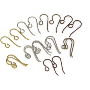 May include: An assortment of metal earring hooks in gold, silver, and bronze hues. The hooks are displayed on a white backdrop, highlighting their diverse forms and finishes. Suitable for jewellery making.