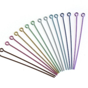 May include: Assortment of 14 head pins with eye loops in various colours, including purple, blue, green, gold, and brown. The head pins are made of metal and are approximately 3.8 cm long.