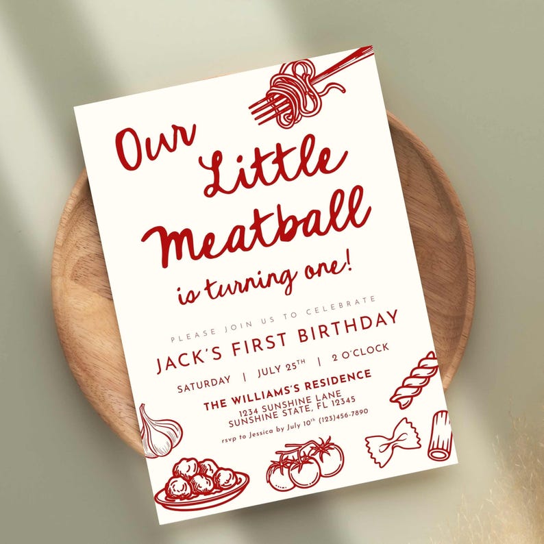 Może przedstawiać: Kremowe zaproszenie z czerwonym tekstem i ilustracjami na pierwsze urodziny. Tekst brzmi "Our Little Meatball is turning one!" ze szczeg&oacute;łami przyjęcia. Zawiera ilustracje z motywem makaronu, w tym spaghetti i klopsiki.