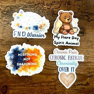 May include: Four stickers with text and illustrations. One says "FND Warrior" with a brain illustration. Another shows a bear with the text "My Flare Day Spirit Animal." A third says "Misfiring Not Imagining." The last says "Chronic Pain, Chronic Fatigue, Chronically Over It."
