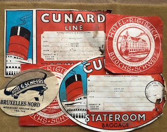 May include: A collection of vintage travel ephemera, including Cunard Line and Hotel Rigiblick labels. The labels feature red, blue, and white designs with ship illustrations and text. Some labels have spaces for passenger information.