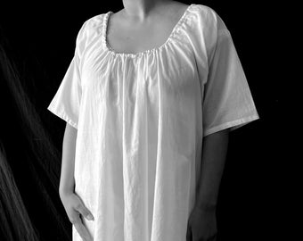 May include: A white, loose-fitting, long-sleeved dress with a gathered neckline.