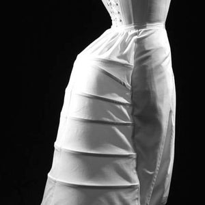 May include: A white cotton petticoat with multiple layers and a ruffled hem. The petticoat is designed to create a full, voluminous silhouette.