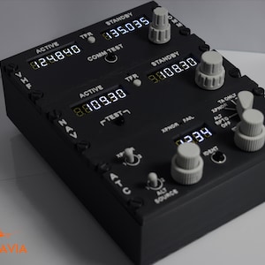 Può includere: Una scatola nera con un display digitale e diversi pulsanti e interruttori. Il display mostra i numeri "824.890", "835.035", "808.30" e "7939". Il testo "ACTIVE", "STANDBY", "TPR", "COMM TEST", "NAV", "TEST", "XPNOR FAL", "TA ONLY", "ALT", "RPTO", "OFF", "ATC", "SOURCE", "TCAS" e "DENT" è anche visibile sulla scatola.
