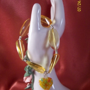 Gele madeliefje hart glaskralen armband