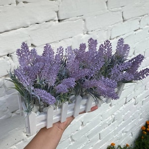 Künstlicher Lavendel in einem hölzernen Blumentopf