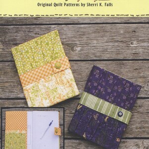 May include: Two fabric-covered notebooks with a green and orange checkered pattern, a purple and green floral pattern, and the text "Gotcha Covered" and "#163".