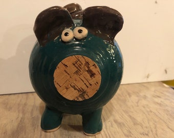 A blue and brown piggy bank with curvaceous tail