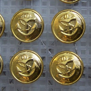 Op de afbeelding: Een set van 16 ovale gouden knoppen met een ankerontwerp. De knoppen hebben een reliëf en een gestructureerd oppervlak.