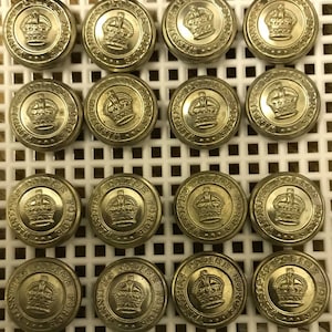 May include: A collection of 16 gold-colored metal buttons with the words "Winnipeg Police Force" and a crown design.